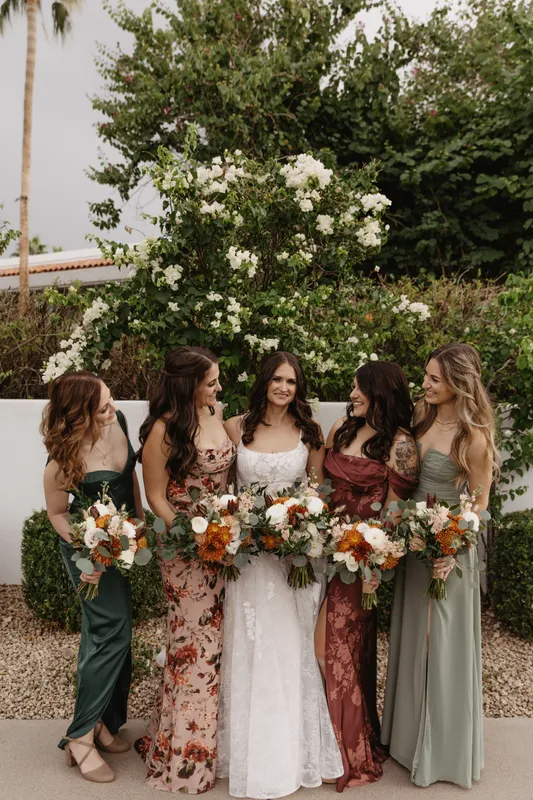 Bride and bridesmaids standing together with bouquets in Gilbert, Arizona, showcasing professional wedding makeup artistry.